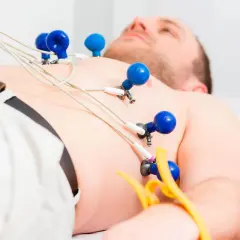 Mężczyzna leży z przyczepionymi elektrodami do badania ekg serca.
