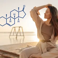 Kobieta medytuje na plaży, obok niej wzór chemiczny DHEA SO4.