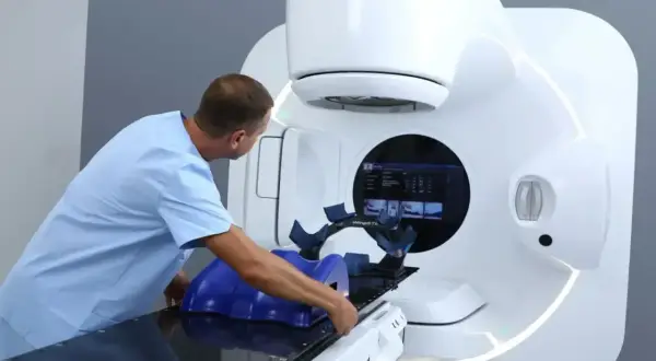 Medyk przygotowuje pacjenta do radioterapii na nowoczesnym aparacie Elekta.
